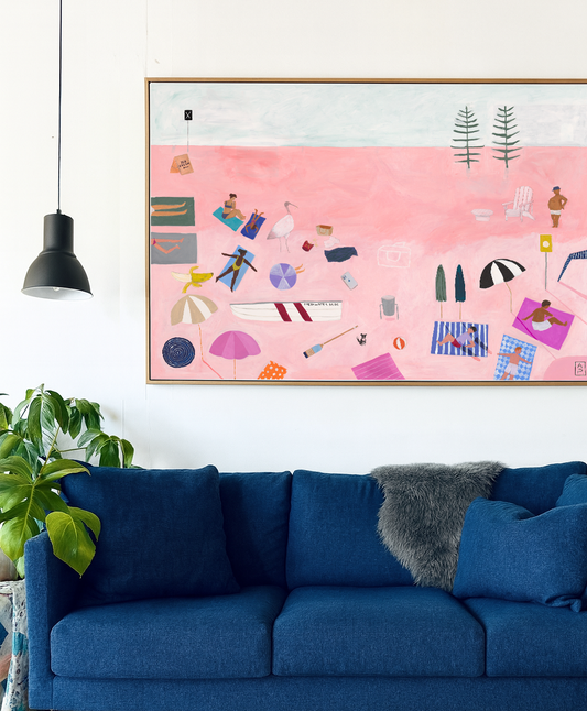 Blue sofa in a living room with a colorful abstract painting on the wall.