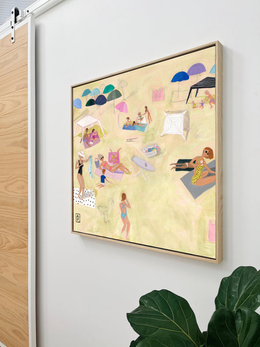 Framed artwork with a colorful beach scene on a white wall.