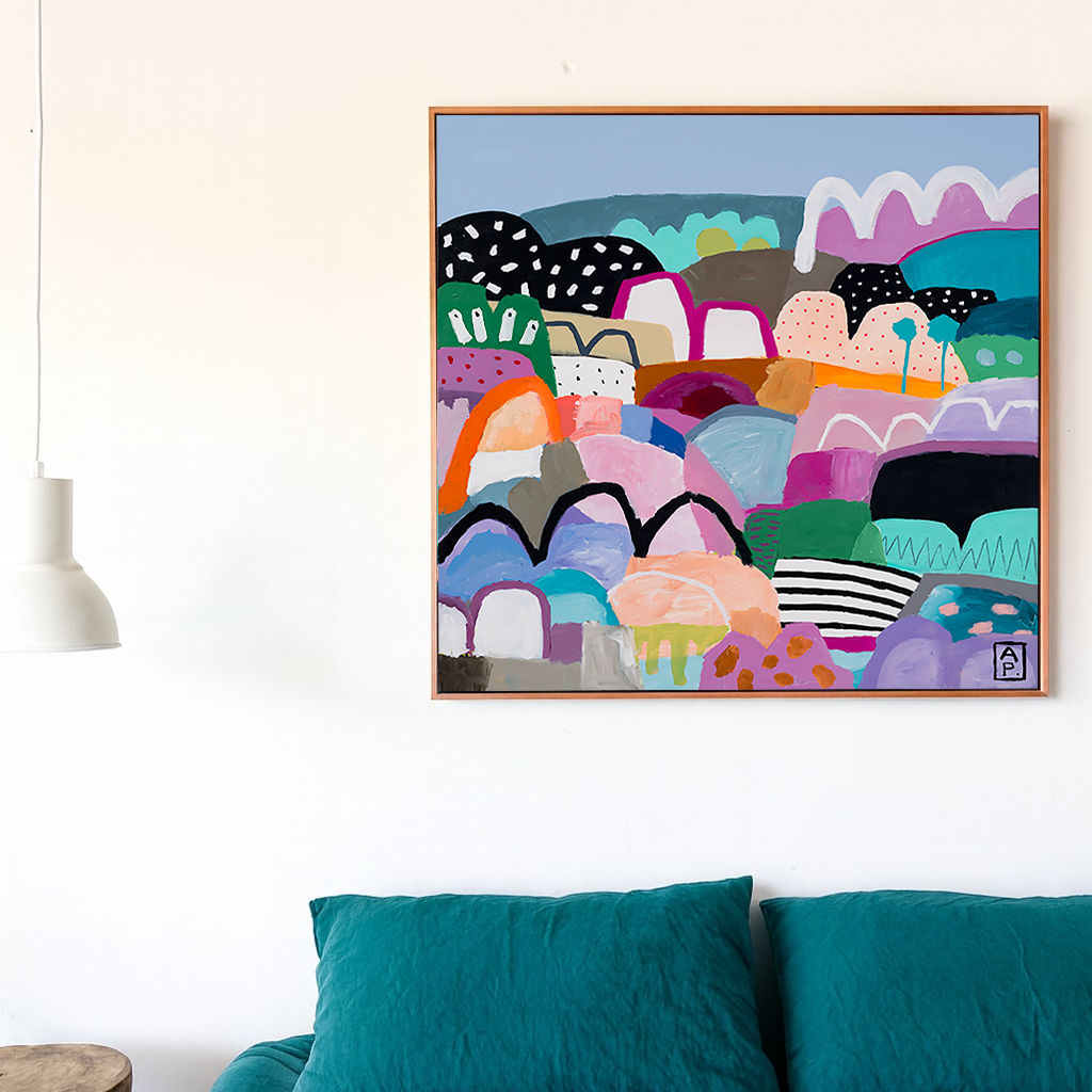 Colorful abstract art piece on a wall above a bed with teal bedding.