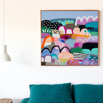 Colorful abstract art piece on a wall above a bed with teal bedding.