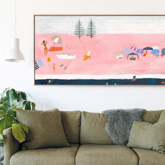 Green sofa in a living room with a colorful beach scene painting on the wall.