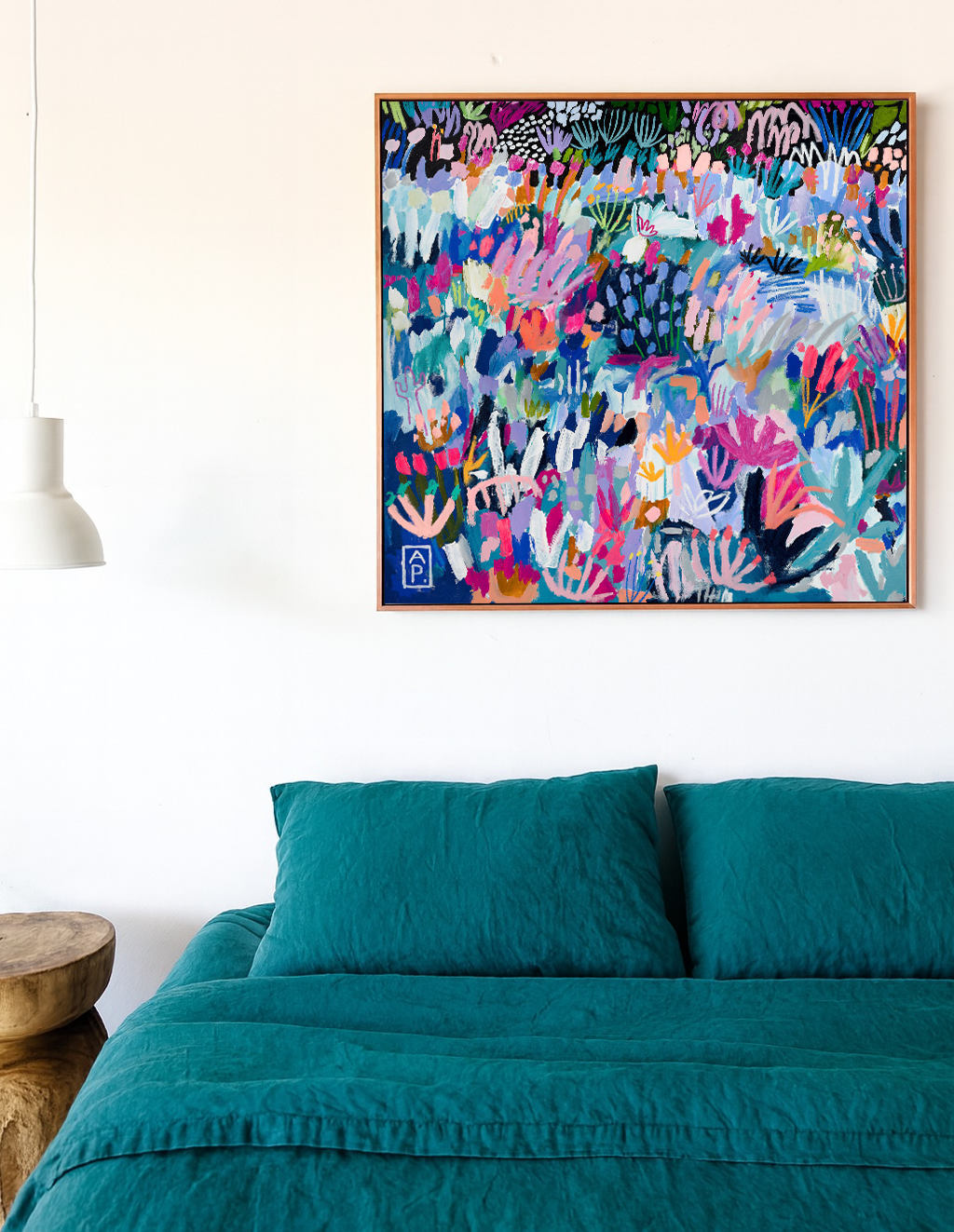 Colorful abstract painting above a bed with teal bedding and pillows.