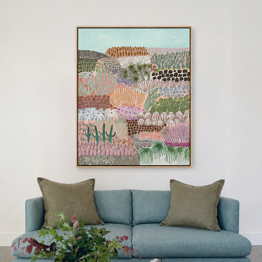 Living room with a blue sofa, framed artwork, and a coffee table with decor items.